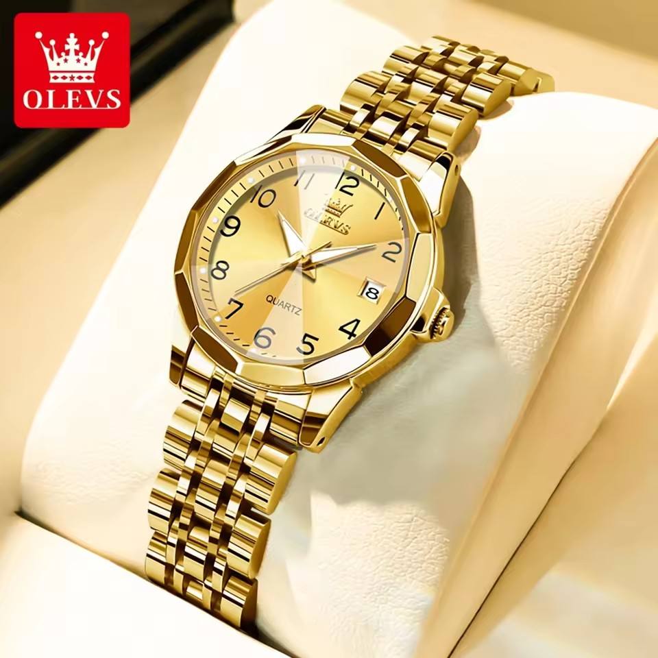 Foto original del reloj OLEVS 9970 dorado sobre cojín, con fecha a las 3 y pulsera de acero