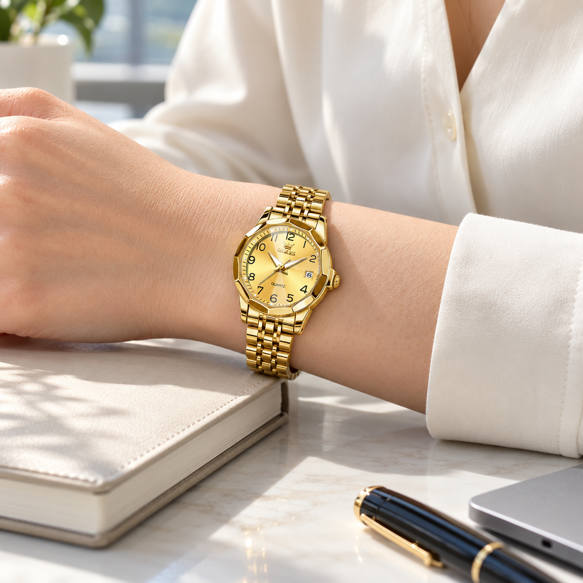 Mujer usando el reloj OLEVS 9970 dorado con blusa clara en un escritorio